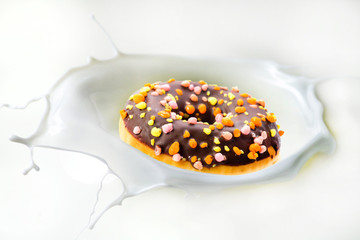chocolate donuts fall into white milk splash