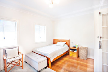Single white bedroom with polished wood floor