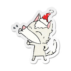 howling wolf distressed sticker cartoon of a wearing santa hat