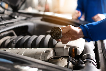 Male mechanic examining car in service center