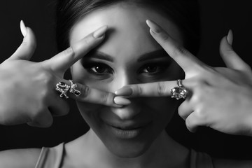 Obraz premium Beautiful girl model shows hands with jewelry. Close up. Beautiful eye. Brunette. Black and white photo