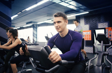 Fototapeta na wymiar Young man training on special sport equipment in gym