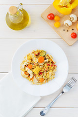 Warm chicken and quinoa salad on a white wooden table