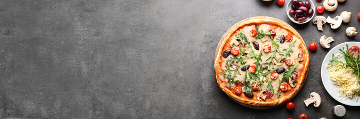 Delicious pizza and ingredients on table