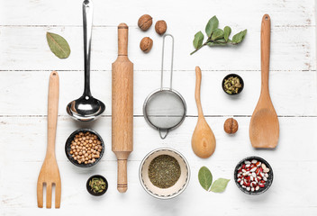 Set of kitchenware and spices on white wooden background
