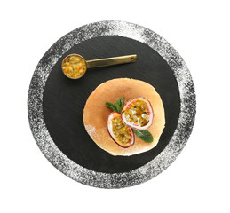 Tasty pancakes with passion fruit on white background