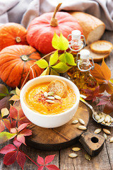 Bowl of pumpkin soup on rustic wooden background