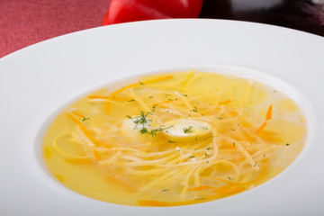 Yellow noodle soup served with quail egg in white plate