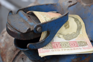Metal barrel and Ukrainian money, the concept of the cost of gasoline, diesel, gas. Refilling the car. Banknote 100 hryvnia.