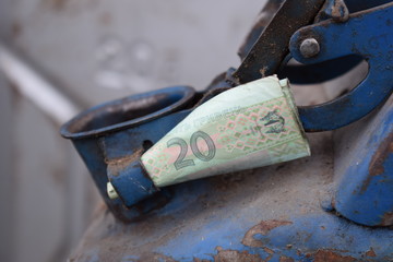 Metal barrel and Ukrainian money, the concept of the cost of gasoline, diesel, gas. Refilling the car. Banknote 20 Ukrainian hryvnia.