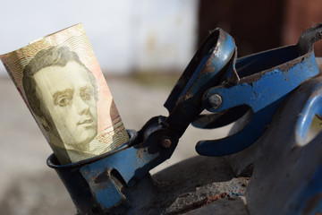 Metal barrel and Ukrainian money, the concept of the cost of gasoline, diesel, gas. Refilling the car. Banknote 100 hryvnia.