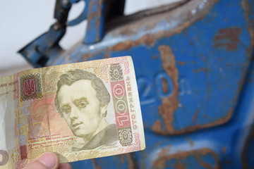 Metal barrel and Ukrainian money, the concept of the cost of gasoline, diesel, gas. Refilling the car. Banknote 100 hryvnia.