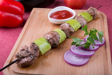 Grilled meat and zucchini ona metal skewer