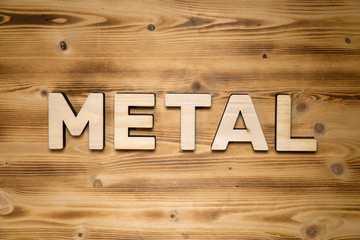 METAL word made of wooden block letters on wooden board.