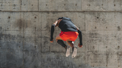 Hispanic Man doing jumping up. Core outdoor workout. Fit man athlete exercising.Wide. urban background