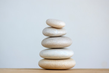 Fototapeta na wymiar Harmony and balance, cairns, simple poise stones on white background, rock zen sculpture, five white pebbles, single tower