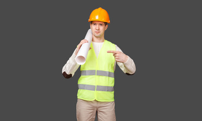 the civil engineer in a helmet points a finger at documents