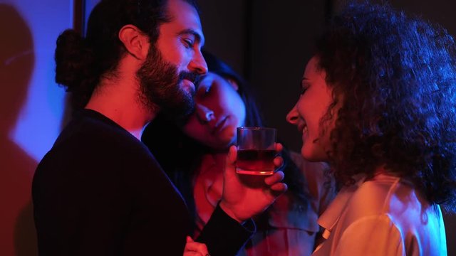 Flirting between three people in night club.polyamory, polygamy, threesome