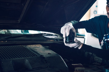 Close up hands of unrecognizable mechanic doing car service and maintenance. Oil and fuel filter...