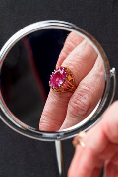 Reflection Of The Ring With Pink Stone On The Finger