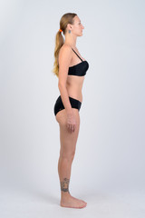 Full body shot profile view of blonde woman wearing bikini