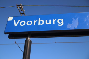 Obraz premium Blue and white name sign Voorburg on the platform of the railway station in the Netherlands