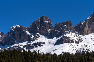 Panoramic view of The Dolomites with forest and mountains against the blue sky in spring, South Tyrol, Italy