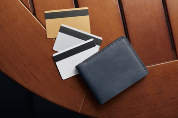 top view of credit cards and leather wallet on wooden table
