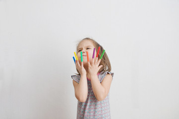 child playing with felt tip pens stuff. baby girl painting and playing. colorful felt pen caps on fingers of kid