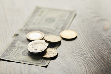 selective focus of dollar banknote and coins on wooden table