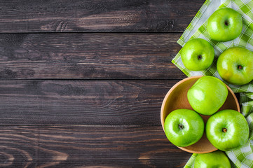 Ripe green apples and apple slices on old wooden background. Place for text. Top view