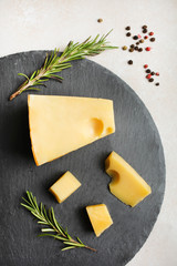 Obraz na płótnie Canvas yellow Maasdam cheese with rosemary and spices