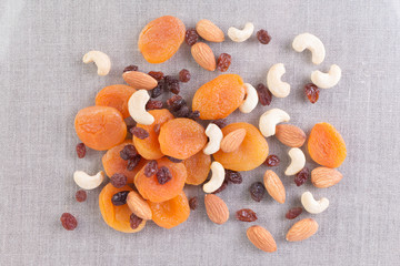 Assortment of nuts and dried fruits . Cashew, almonds, raisins, dried apricots on tablecloth. Top...