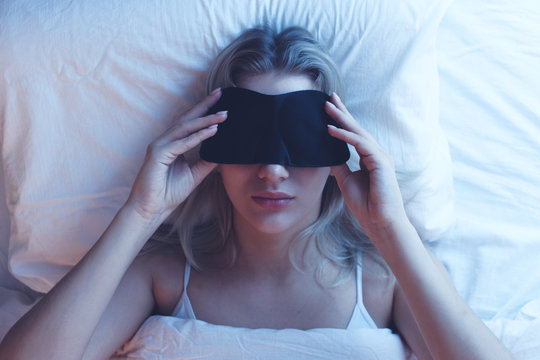 Sleeping Girl In A Sleep Mask On An Orthopedic Pillow With Night Lighting, White Bed Linen.