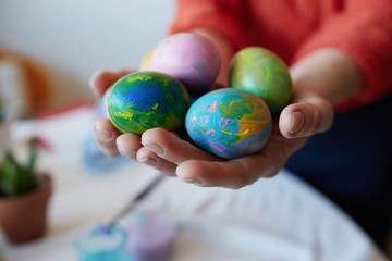 Female hands holding painted colorful easter eggs. Happy easter decoration at sweet home