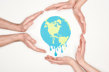 cropped view of women and men surrounding paper cut melting globe with hands on white background, global warming concept