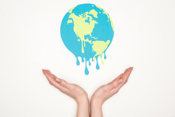 cropped view of woman holding open hands under paper cut melting globe on white background, global warming concept