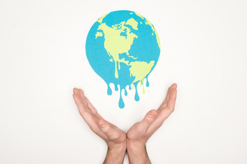 cropped view of male hands under paper cut melting earth on white background, global warming concept