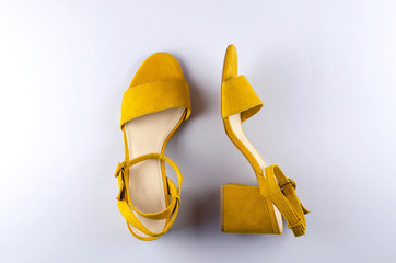 Two sandals mustard color gray background.