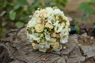 Obraz na płótnie Canvas wedding bridal bouquet in white and gold colors and wedding rings