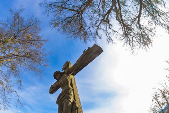 carving of Jesus crucified between trees