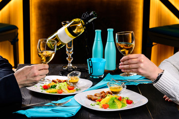 romantic dinner in a restaurant, hands with wine glasses