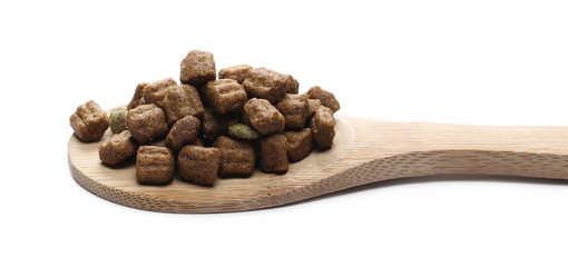 Dry dog food, granules with wooden spoon isolated on white background