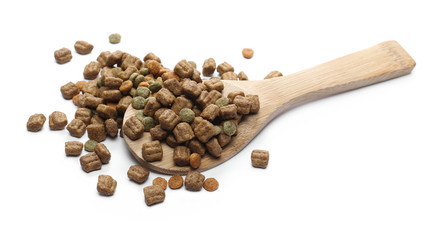 Dry dog food, granules with wooden spoon isolated on white background