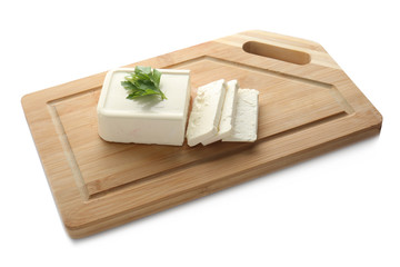 Board with tasty feta cheese on white background