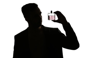 Silhouette of handsome man with bottle of perfume on white background