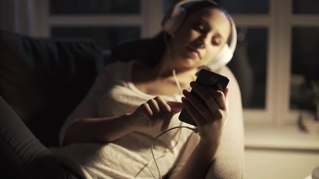Woman listening to music at night and relaxing