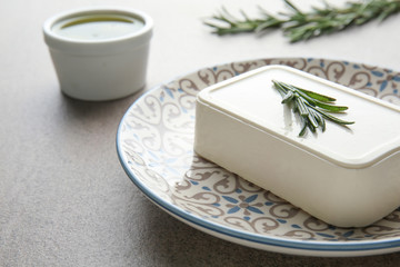 Plate with tasty feta cheese on table, closeup