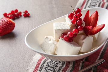 Tasty feta cheese with berries in bowl