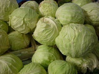 Fototapeta na wymiar Closeup view stack of green fresh cabbages for sale at a supermarket ideal healthy food for vegan and vegetarian people